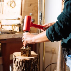A goldsmith using a ball punch for dapping